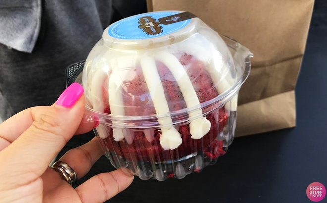 A person holding a Nothing Bundt Red Velvet Case Cake